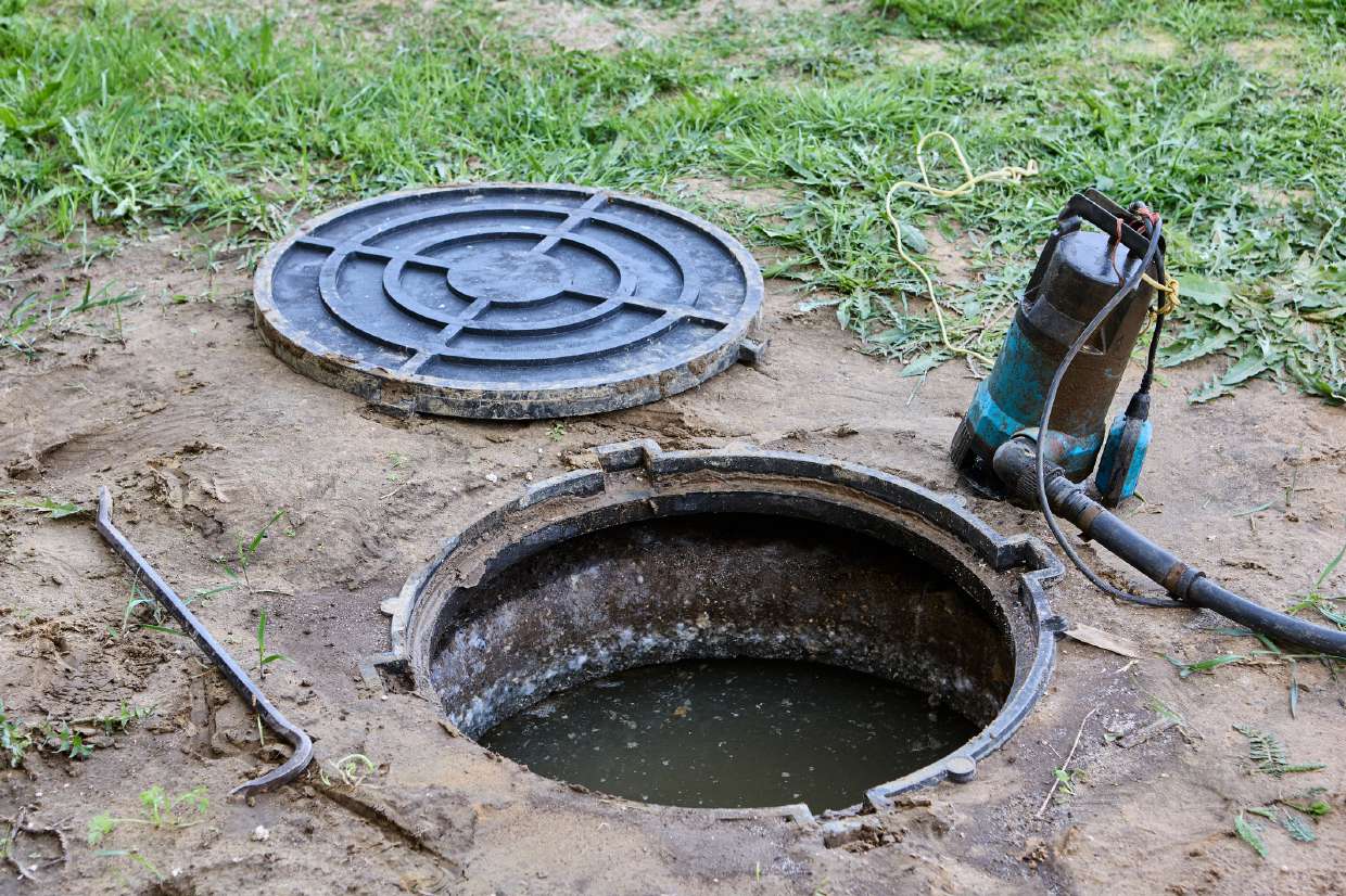 Open septic manhole with a pump during service