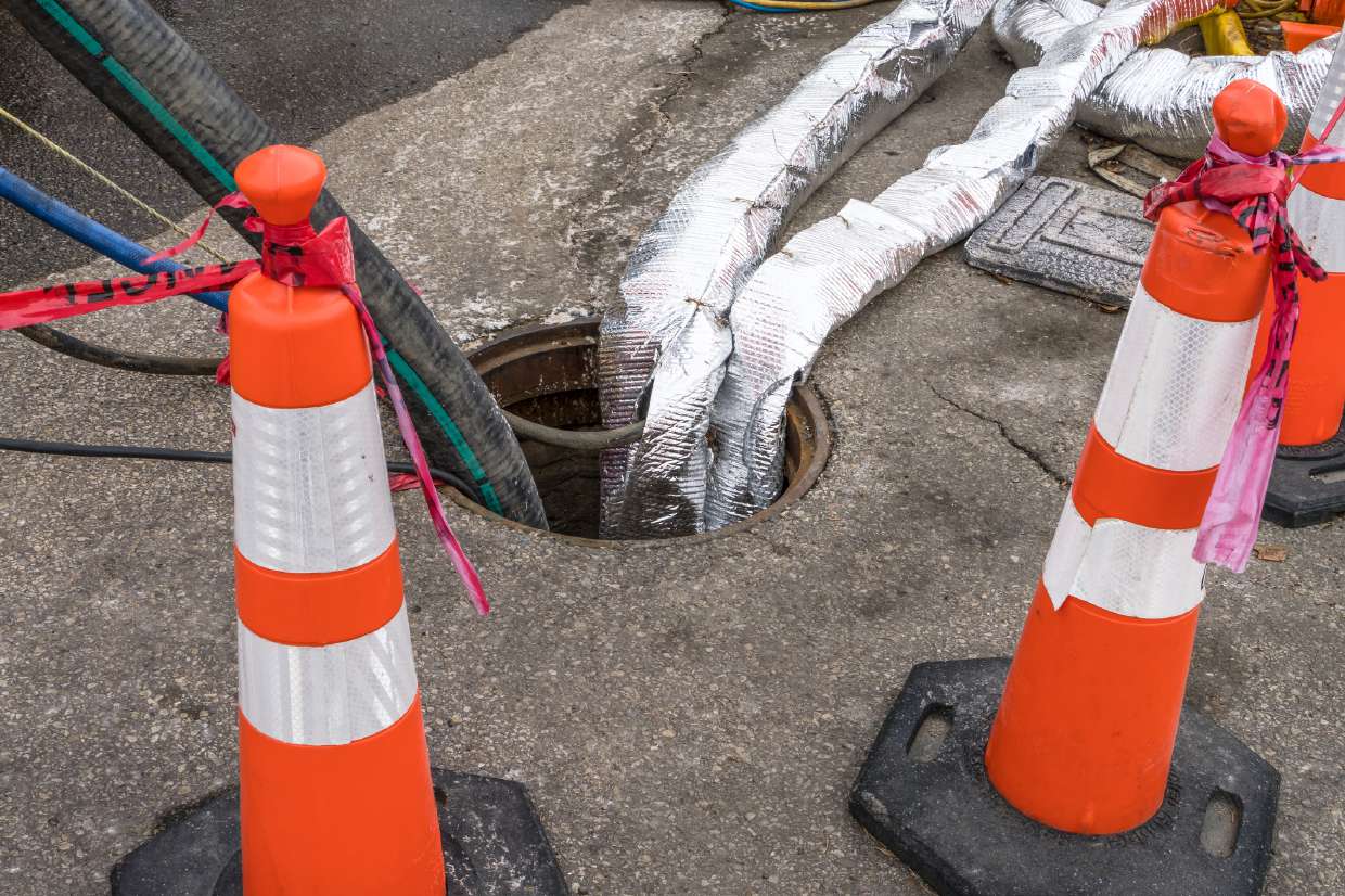 Sewer Snaking / Roto-Rooter Service in Kingston, NY — Safety cones around an open manhole during service
