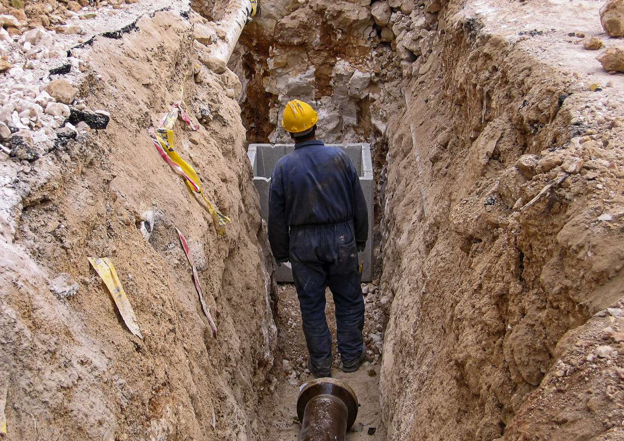 Septic Repair project in Hurley, NY — Worker in an open trench during septic line excavation
