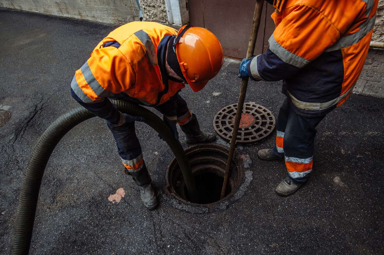 Crew pumping and clearing a sewer manhole