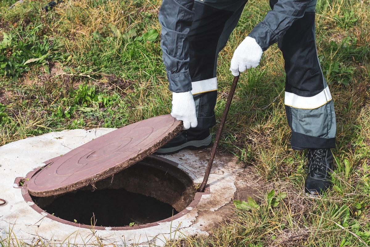 Choosing the right professional: a septic specialist opens the tank lid to begin a full system inspection.