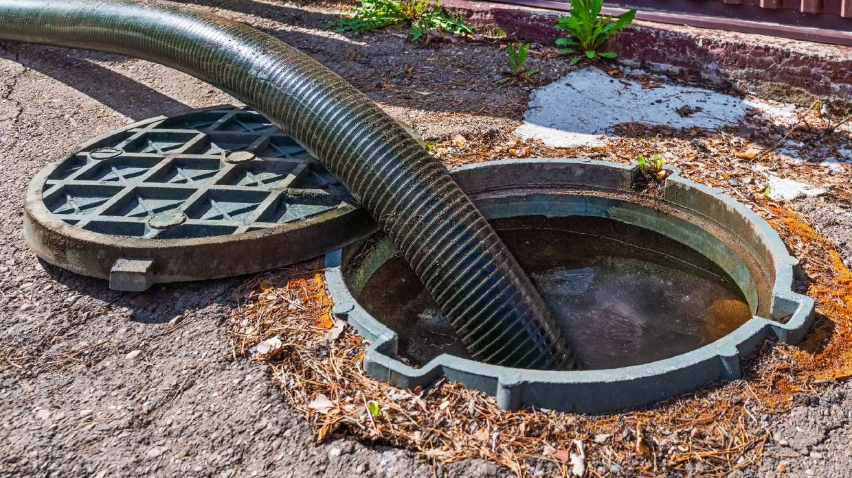 Sewer Camera Inspection in Kingston, NY — Suction hose lowered into a street sewer manhole