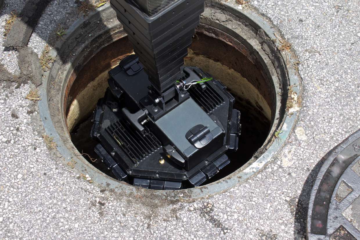 Sewer Camera Inspection in Kingston, NY — Overhead view of equipment lowered into a manhole